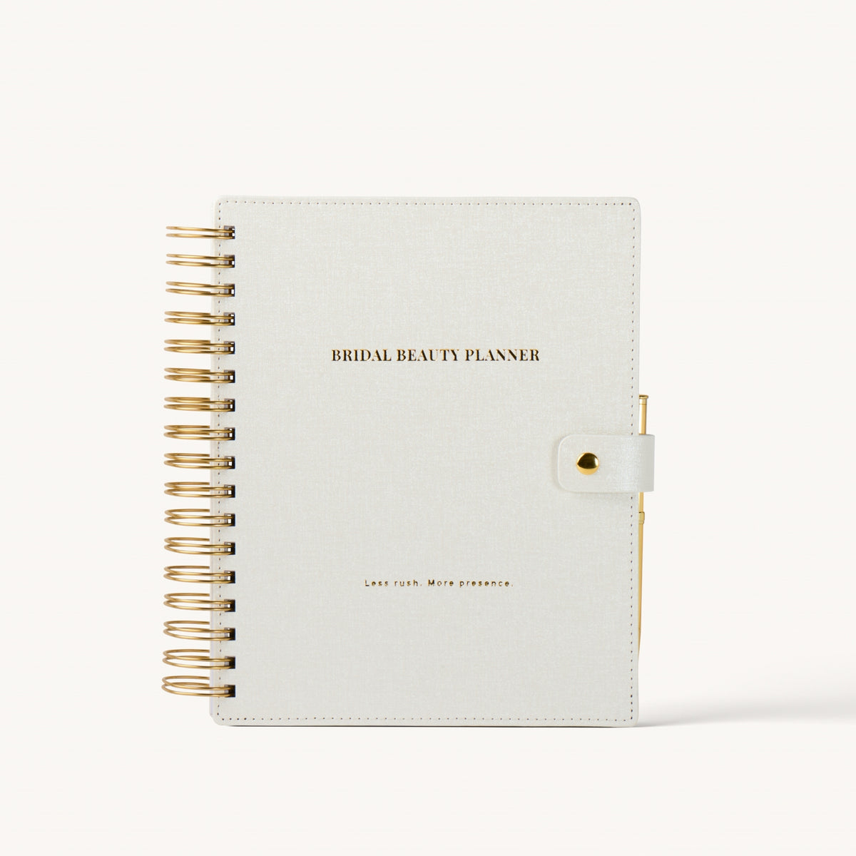 A bridal beauty planner notebook with a textured off-white cover, gold wire spiral binding on the left, and a gold snap closure on the right. The cover features the text 'BRIDAL BEAUTY PLANNER' in gold.